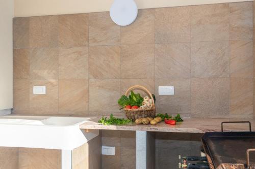 a kitchen counter with a basket of vegetables on it at Apartman Ivona in Malinska