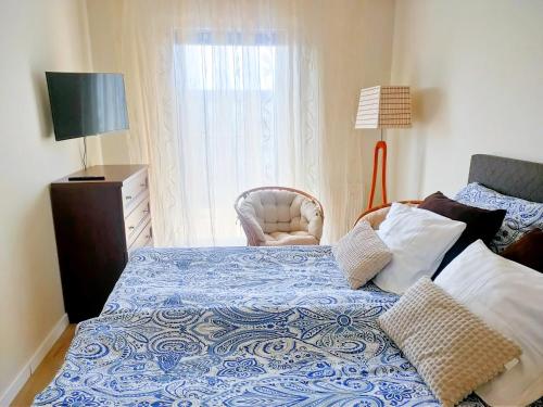 1 dormitorio con 1 cama, 1 silla y 1 ventana en AURA Delux Seaside, en Dziwnów