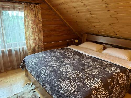 1 dormitorio con 1 cama en una cabaña de madera en Kazkova khatynka en Bushtyno