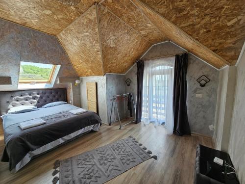 um quarto com uma cama grande e um tecto de madeira em Vila Kalibu em Piatra Neamţ