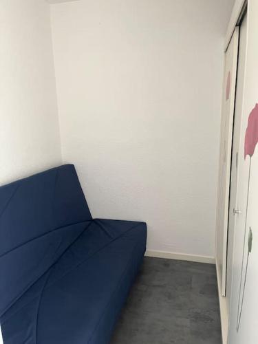 Habitación con cama azul en una habitación en Studio 4 pers proche de la mer, en Camiers