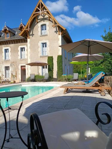 - un bâtiment doté d'une piscine avec des chaises et des parasols dans l'établissement Château d'Arfeuilles Chambres et tables d'hôtes, à Arfeuilles