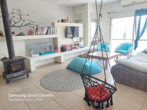 a living room with a swing in a room at הממלכה הקסומה של מאיה ושלושת הפיות in Gonen