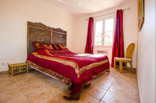 - une chambre avec un lit doté de draps rouges et une fenêtre dans l'établissement Grande Villa à Sainte Maxime - Golfe de Saint Tropez, à Sainte-Maxime