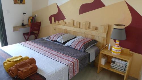 1 dormitorio con 1 cama con cabecero de madera en KAZ à LILO en Petite Île