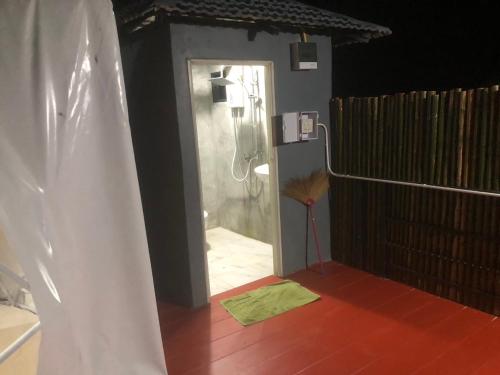 a bathroom with a shower in a room with a door at เชียงของฮิลล์ รีสอร์ท 