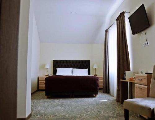 a bedroom with a bed and a television in it at Pasažo namai B&B in Raseiniai