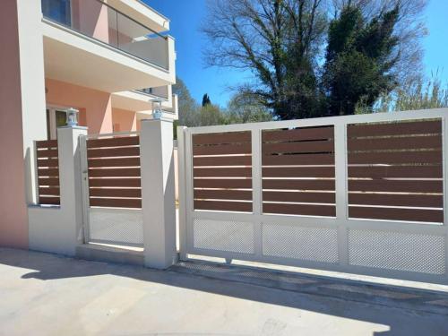 a white fence in front of a house at AVRA-3 Luxury Apartment in Potamós