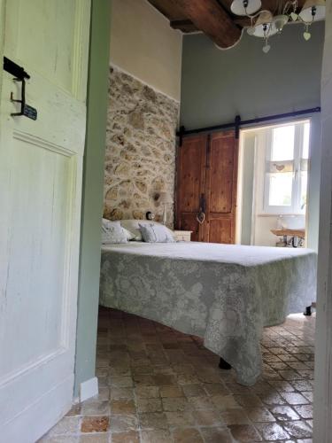 a bedroom with a bed in a room with a stone wall at B&B L'Usignolo in Ascoli Piceno