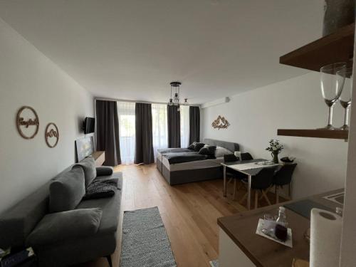 a living room with a couch and a table at Wolfgangsee Ferienappartement „Bergliebe“ in Strobl