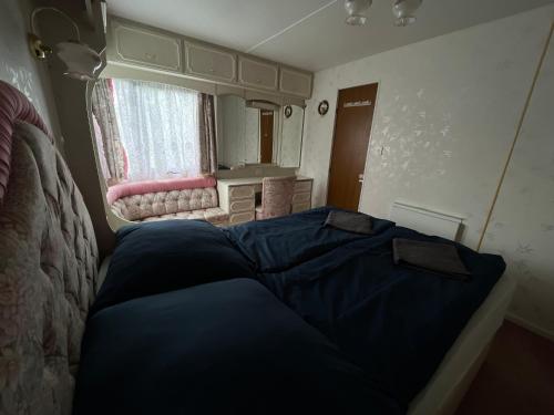 a bedroom with a blue bed and a window at Autocamp Free Star - Mobilheimy in Strachotín