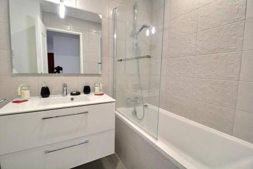 a white bathroom with a sink and a shower at Bulle de bonheur ! Appartement avec deux chambres in Colombes