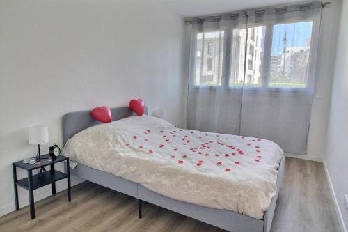 a bedroom with a bed with red roses on it at Bulle de bonheur ! Appartement avec deux chambres in Colombes