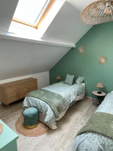 une chambre mansardée avec deux lits et une lucarne dans l'établissement La Blériotine, à Sangatte