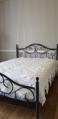 un lit noir avec une couette blanche dessus dans l'établissement La villa des chimères, à Sarlat-la-Canéda