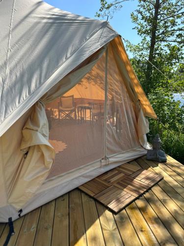 a tent sitting on top of a wooden deck at Glamping on idyllic lake, paddle boards & rowboat in Porsgrunn