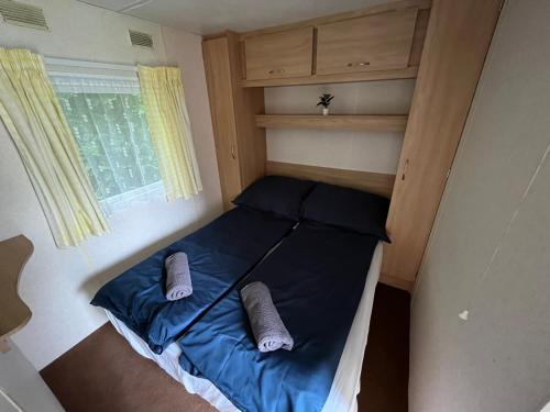 a small bed in a small room with a window at Autocamp Free Star - Mobilheimy in Strachotín