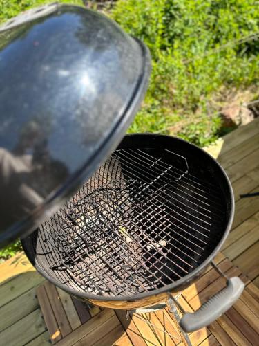 a grill sitting on top of a deck with a grill at Glamping on idyllic lake, paddle boards & rowboat in Porsgrunn