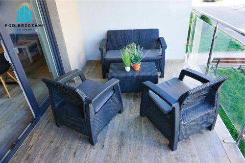 a group of chairs and a table on a balcony at Pod Brzozami Apartamenty 5 Mórz in Ustronie Morskie