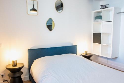 1 dormitorio con 1 cama y 2 luces en la pared en Joli T2 - Hennebont centre, en Hennebont