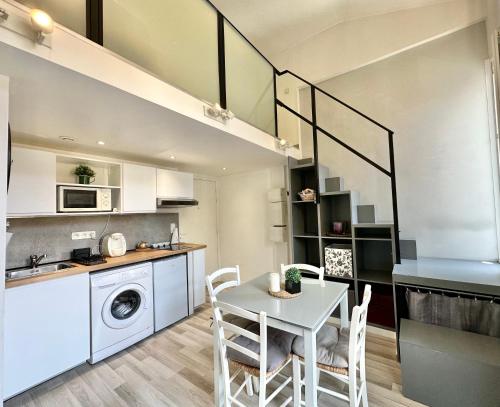une cuisine et une salle à manger avec une table et des chaises blanches dans l'établissement Studio - Clim AC - 5min beach walk - 2min tramway, à Nice