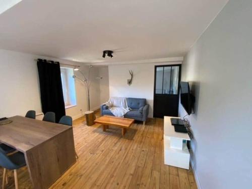 un salon avec un canapé et une table dans l'établissement Le Chalet - Appartement 5 personnes avec parking, à Savignac-les-Ormeaux