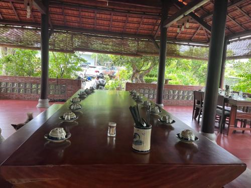 a long table in a restaurant with chairs and tables at SUỐI RAO VALLEY - cách Hồ Tràm 17km in Ấp Xuân Khai