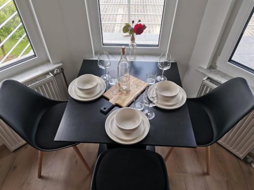 a black dining room table with chairs and wine glasses at Apartma KORPEC in Ivanjkovci