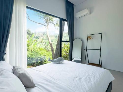 1 dormitorio con cama blanca y ventana grande en Thalassaville Dago Bandung en Bengkok