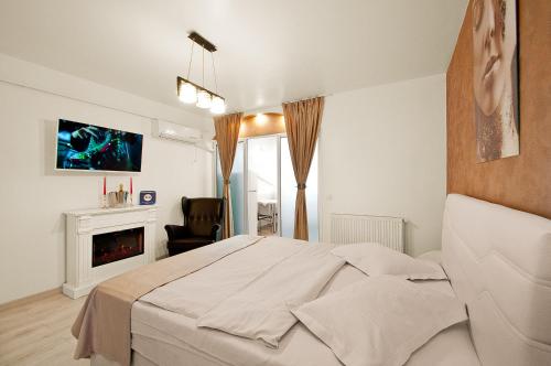 a white bedroom with a bed and a fireplace at Danube Residence in Galaţi