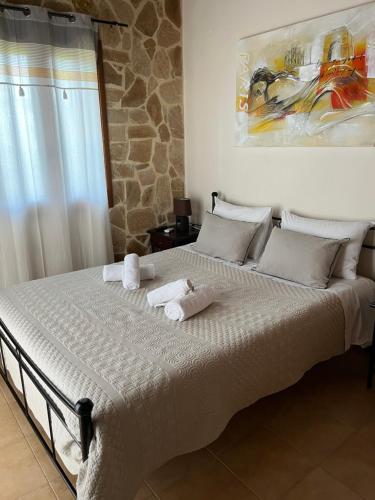 a bedroom with a large bed with towels on it at Villa Calliopé avec vue imprenable, jardin et piscine privée in Glóssa