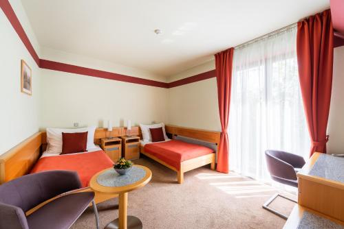 ein Wohnzimmer mit einem Sofa, Stühlen und einem Fenster in der Unterkunft Jan Maria Hotel & Restaurant in Ostrava