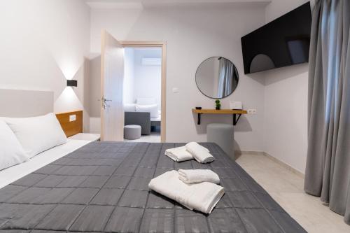 ein weißes Schlafzimmer mit Bett und Spiegel in der Unterkunft Pantzos House in Paradisos