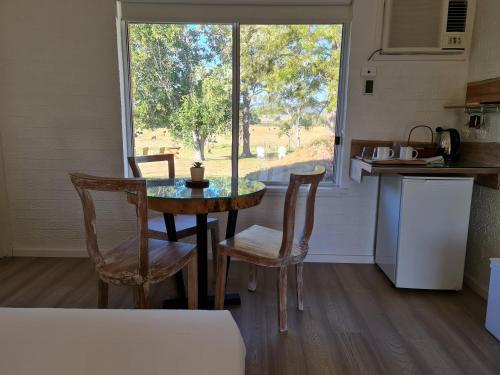 a kitchen with a table and chairs and a window at Vacy Hunter Valley Lodge in Vacy