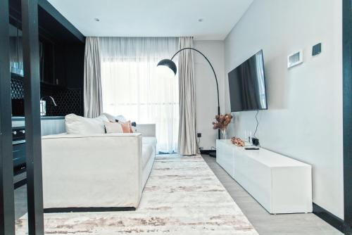 uma sala de estar branca com um sofá branco e uma televisão em Fine Living Mai Tai em Nairobi