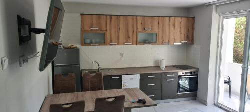 Una cocina con gabinetes de madera y una mesa de madera. en Apartment Blue Adriatic Tivat, en Tivat