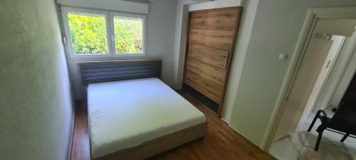 een kleine slaapkamer met een bed en een raam bij Apartment Blue Adriatic Tivat in Tivat