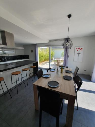 - une salle à manger et une cuisine avec une table et des chaises en bois dans l'établissement Le 6 : maison individuelle au cœur de l'Alsace, à Turckheim