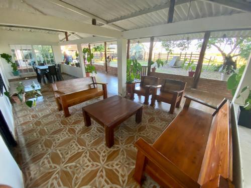 a living room with wooden tables and chairs at Hacienda Veracruz in Villagarzón
