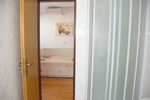 a door leading to a room with a bed at Apartments Summersong in Novalja
