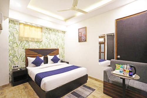 a hotel room with a bed and a chair at Hotel GL Suites Near Delhi Airport in New Delhi