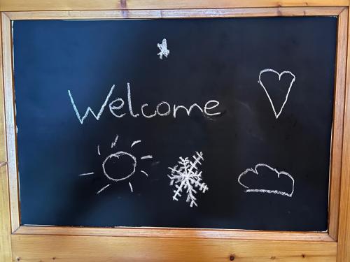 a chalkboard with the words welcome written on it at ZE Mountain Lodge, Morgins in Morgins