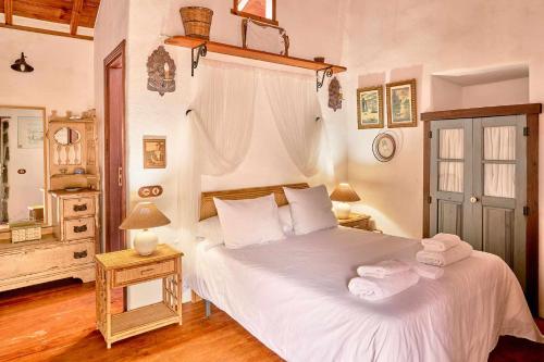Un dormitorio con una cama blanca con toallas. en Finca Arce Live Canarias en Tacoronte
