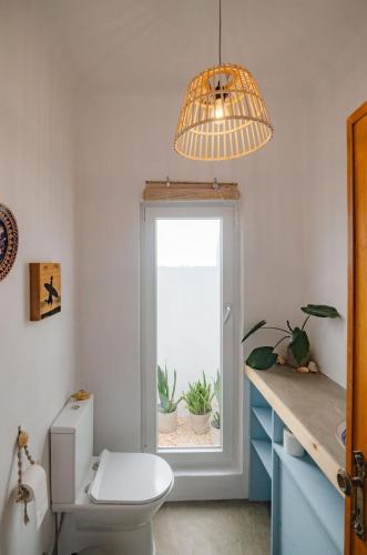 a bathroom with a toilet and a window with plants at Little Bispo Apartments in Vila do Bispo