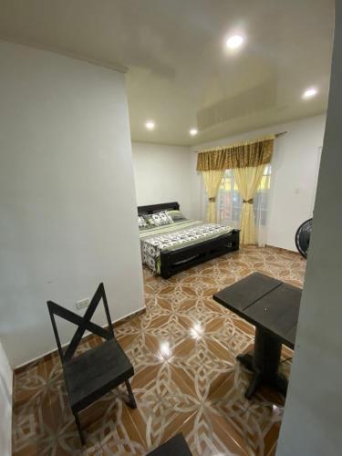 una camera con letto, tavolo e sedie di Hacienda Veracruz a Villagarzón