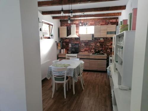 eine Küche mit einem Tisch und einem weißen Tischtuch in der Unterkunft CasAndi in Cireşu