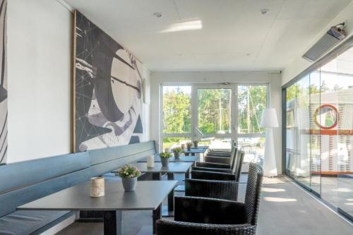 a row of tables and chairs in a room with windows at Marina Martinshafen - Beach life in Sassnitz