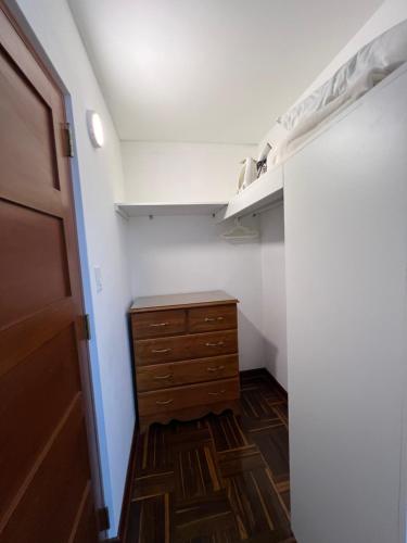 a small bedroom with a dresser and a closet at San Isidro Olivar 2 bedroom Apartment in Lima