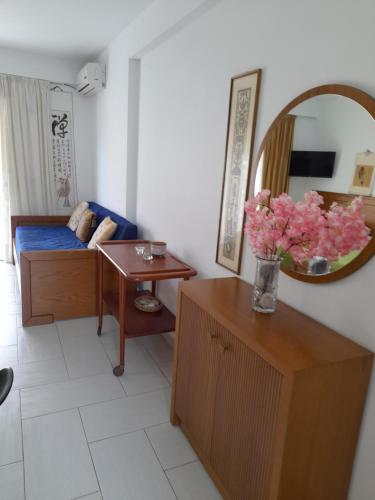 sala de estar con sofá y mesa con flores en Menikos Apartments, en Himare