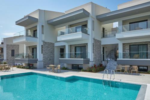 an apartment building with a swimming pool in front of it at GreyStoneApartments in Paralia Dionysiou